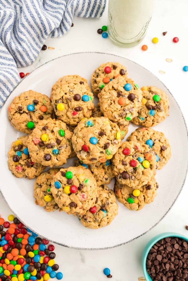 Monster cookies on a plate with milk on the side.