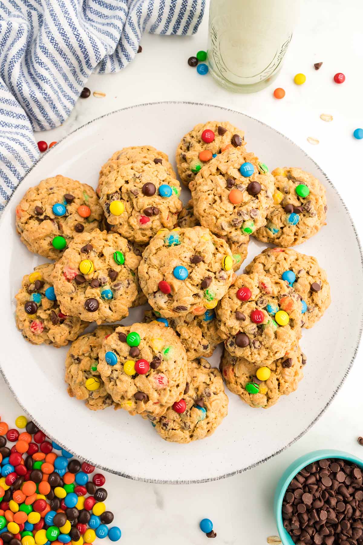 Monster cookies on a plate with milk on the side. 