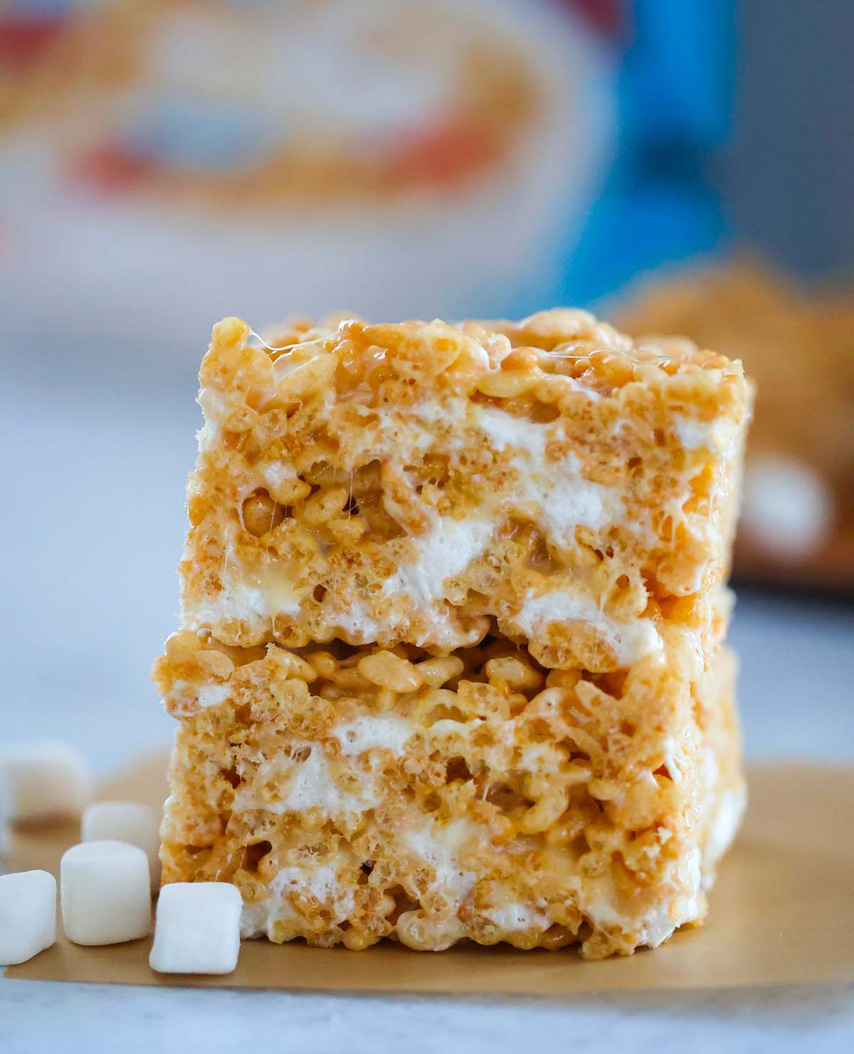 two rice krispie treats stacked with marshmallows on the side. 