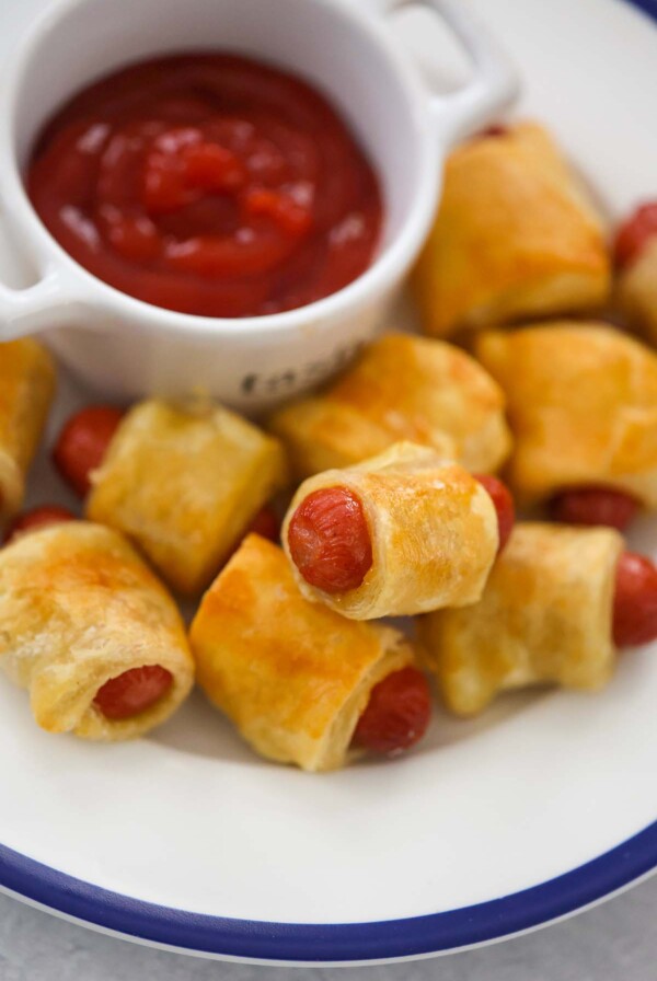 pigs in a blanket with ketchup on the side.
