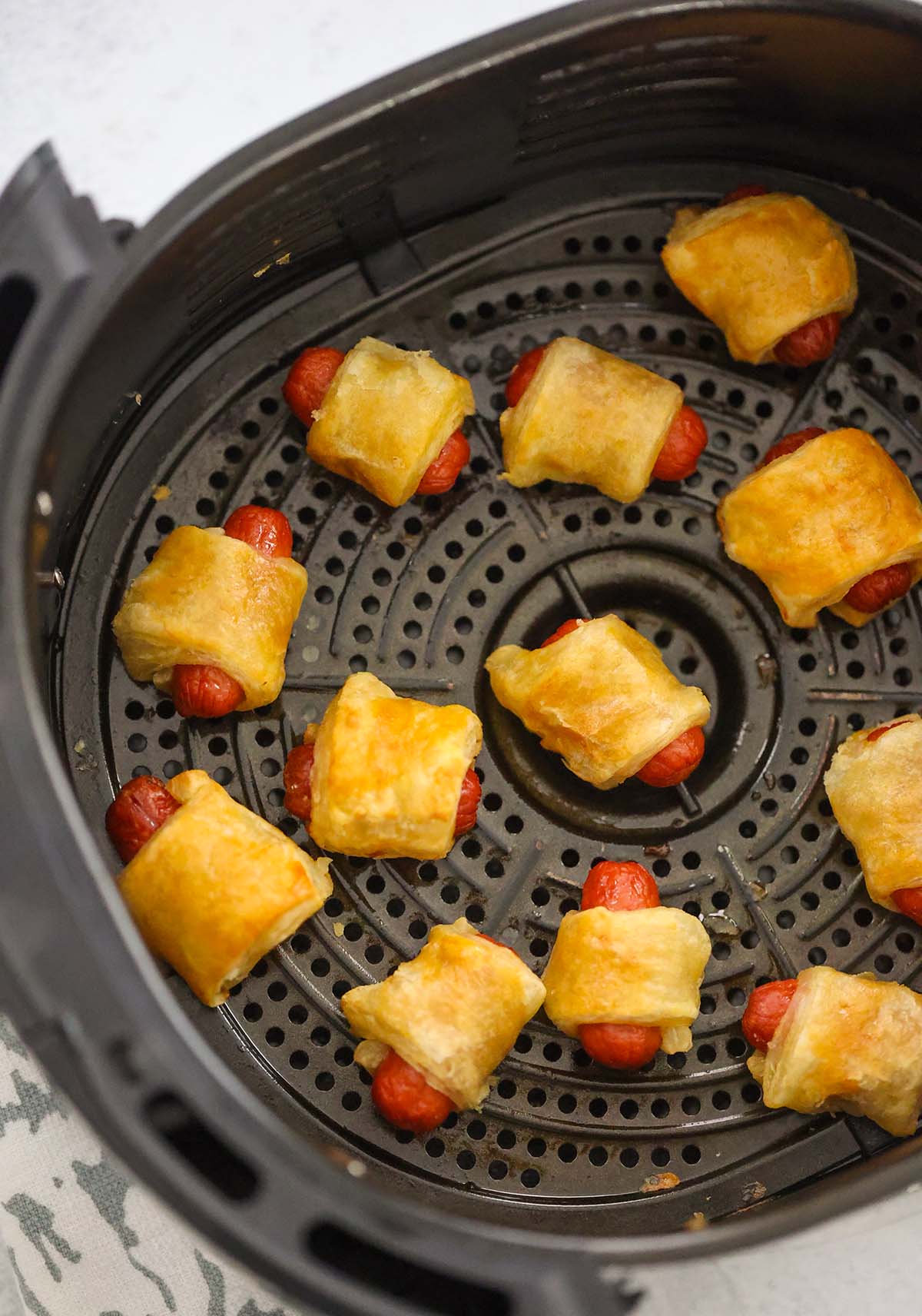 cooked pigs in a blanket in the air fryer basket. 