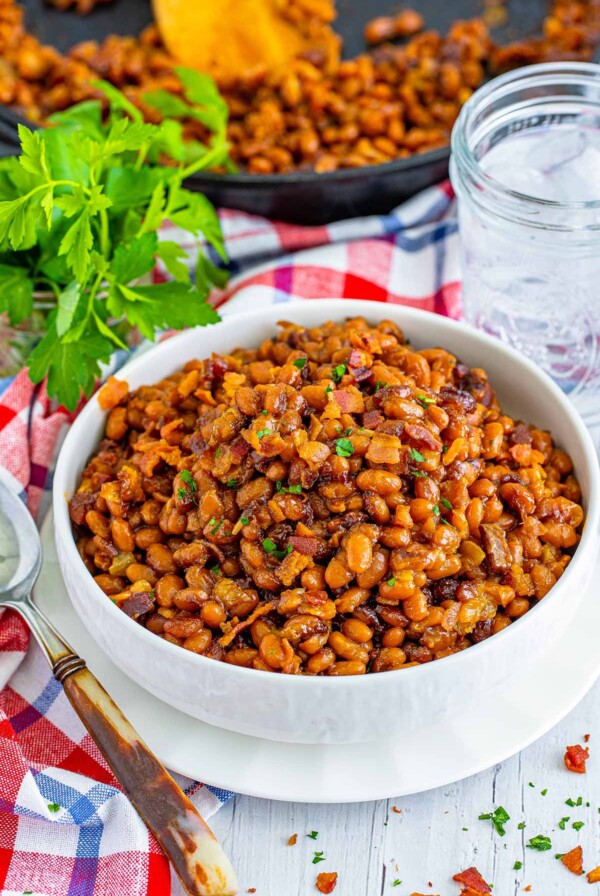 a bowl of baked beans with bacon on top.