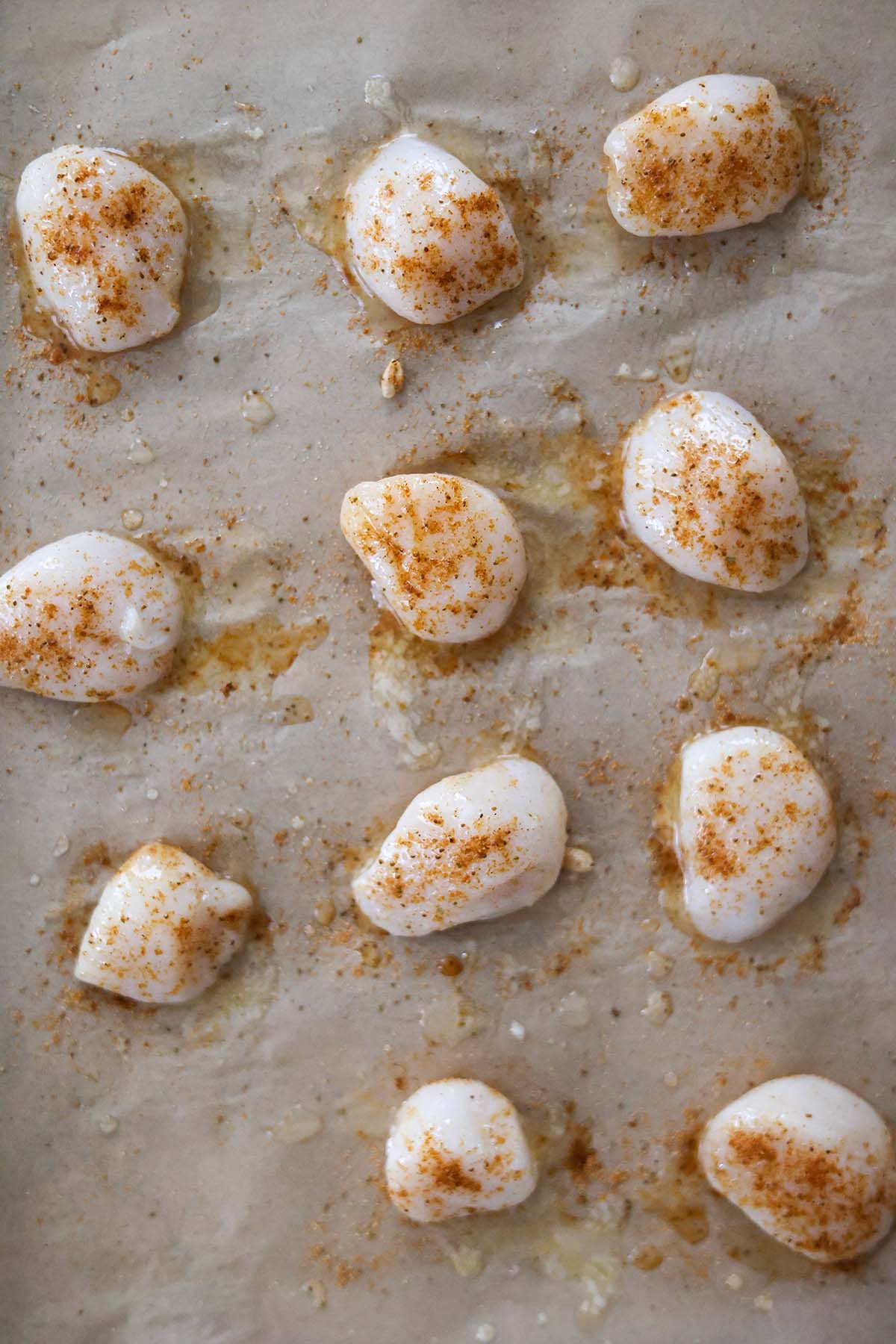 seasoned sea scallops on a baking sheet 