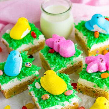 Easter sugar cookie bars with jelly beans, milk, and peep candies on the side.