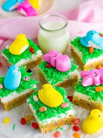 Easter sugar cookie bars with jelly beans, milk, and peep candies on the side.