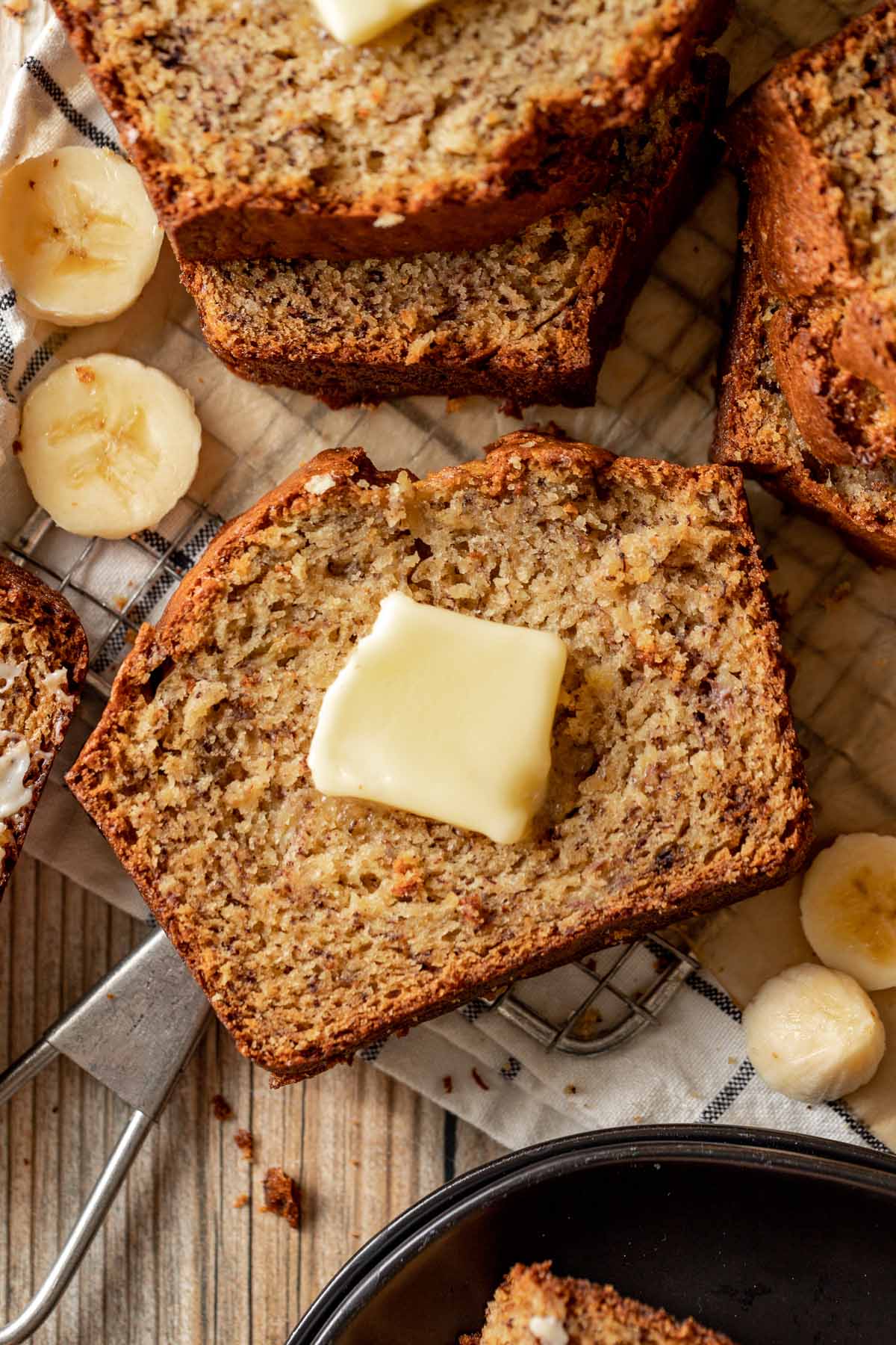 moist banana bread slice with softened butter on top. 