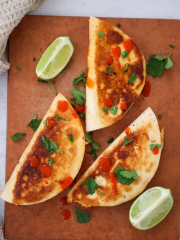 cheesy buffalo chicken tacos with lime wedges on the side.