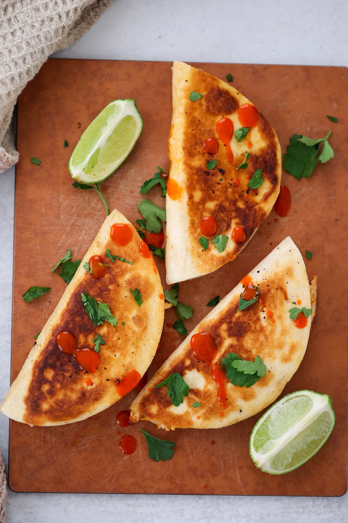 cheesy buffalo chicken tacos with lime wedges on the side. 