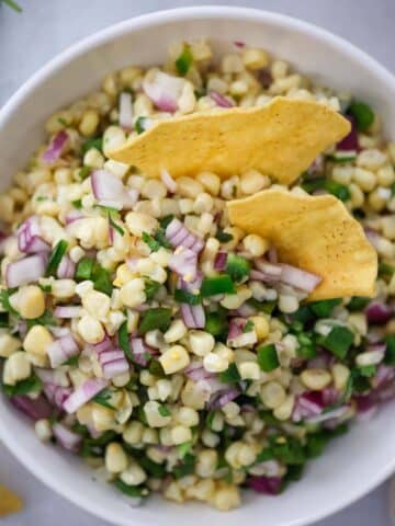 roasted chili corn salsa in a bowl with tortilla chips.