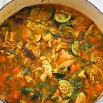 spicy chicken noodle soup in a dutch oven.