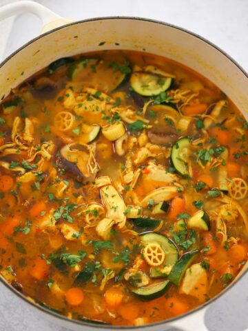 spicy chicken noodle soup in a dutch oven.