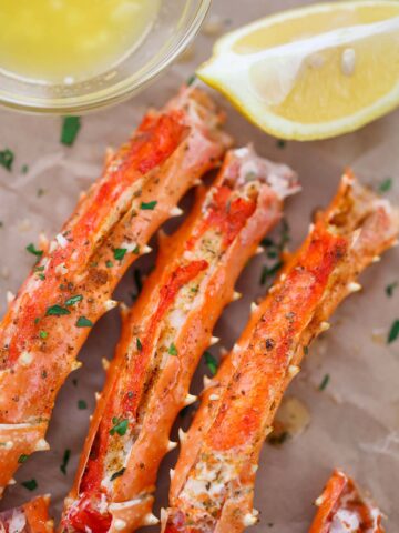 baked king crab legs with butter and lemon on the side.