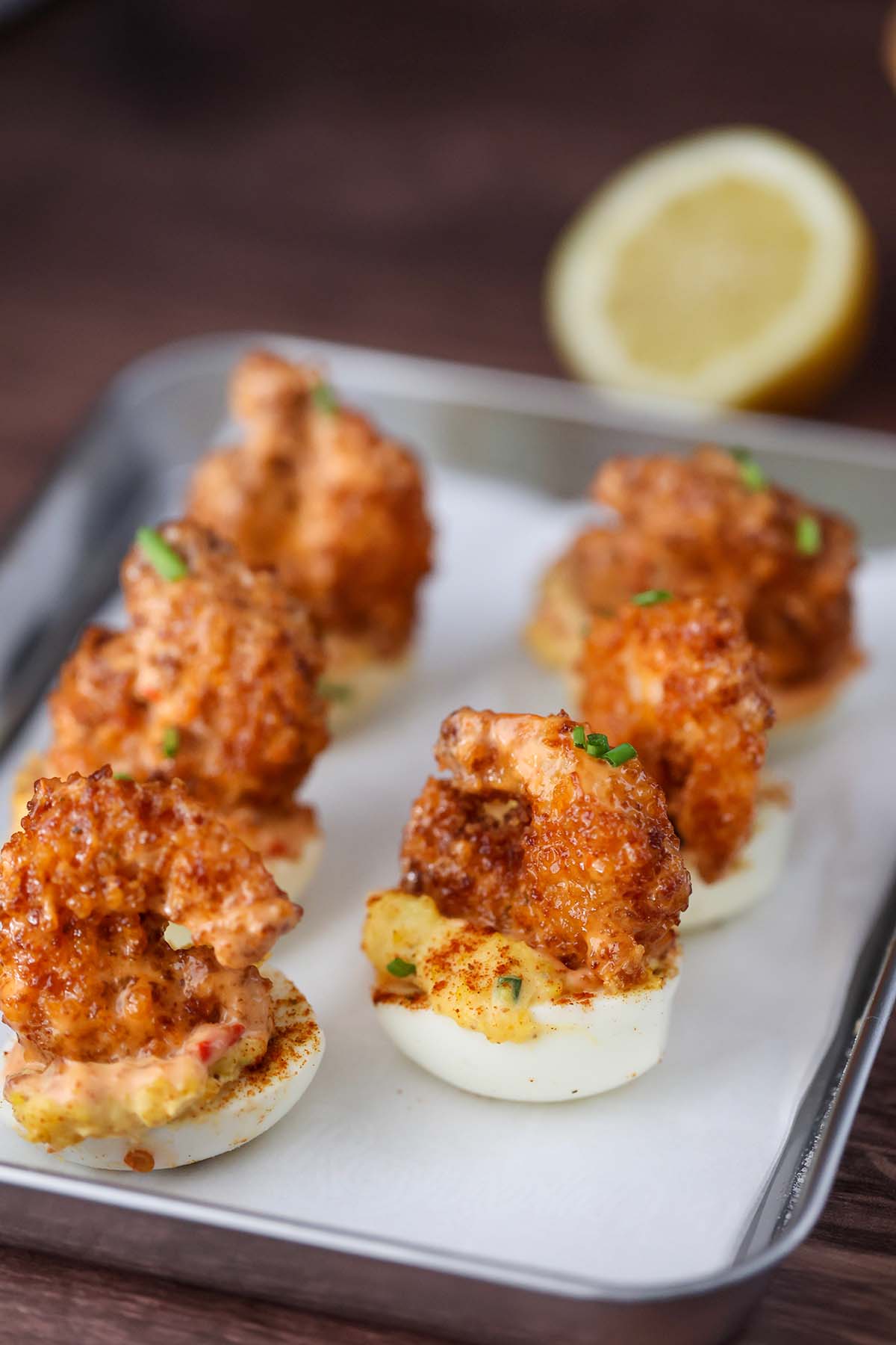 six deviled eggs with fried shrimp on top. 