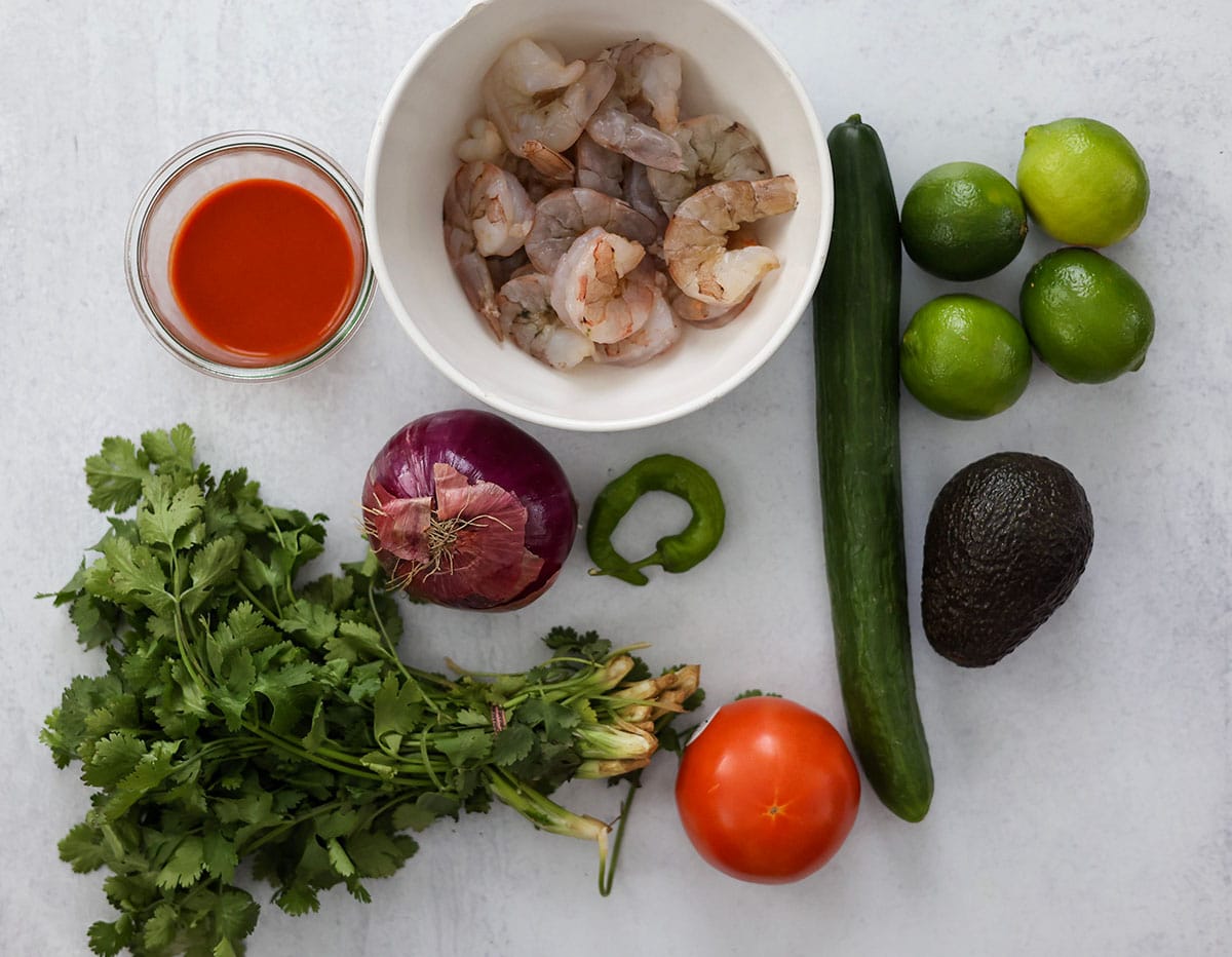 shrimp, hot sauce, limes, cucumber, tomato, green chili, red onion, avocado, and cilantro. 