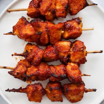 five air fryer chicken kabobs on a white plate