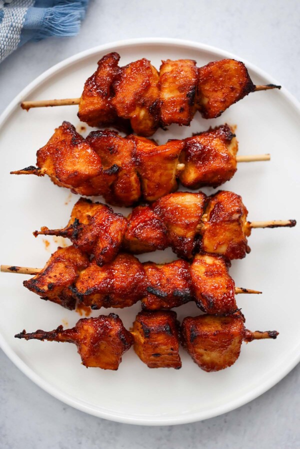 five air fryer chicken kabobs on a white plate