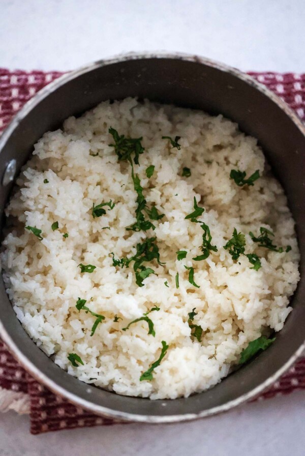 coconut rice in a saucepan with cilantro on top.