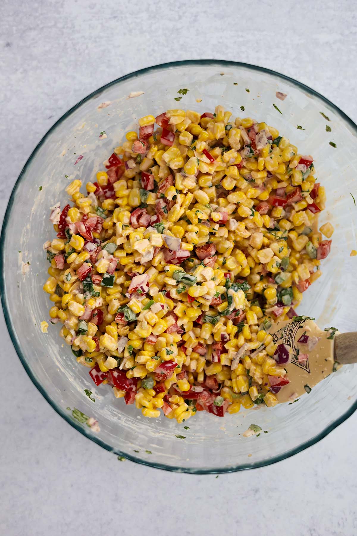 corn salad in a bowl with a rubber spatula. 