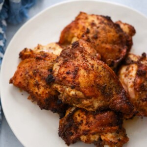 roasted chicken thighs on a white plate.