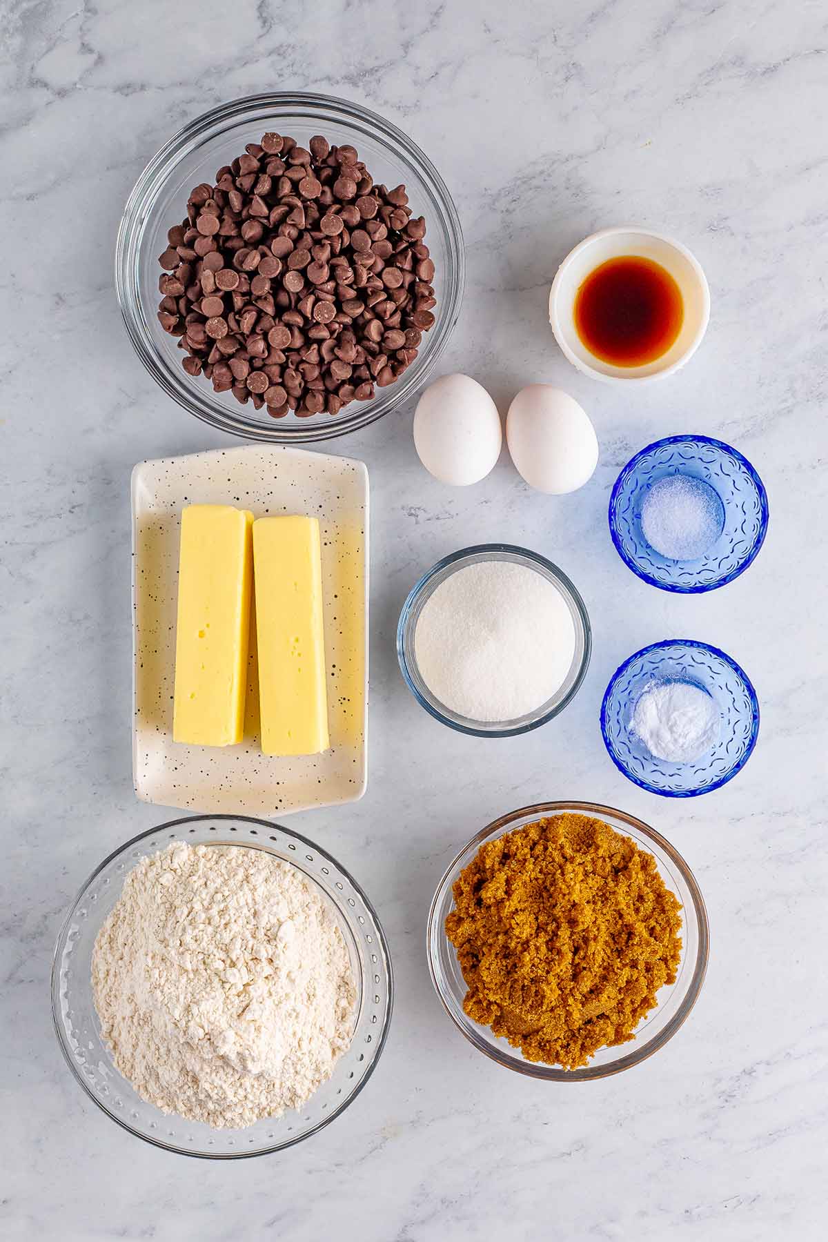 ingredients for chocolate chip cookies on a white surface. 
