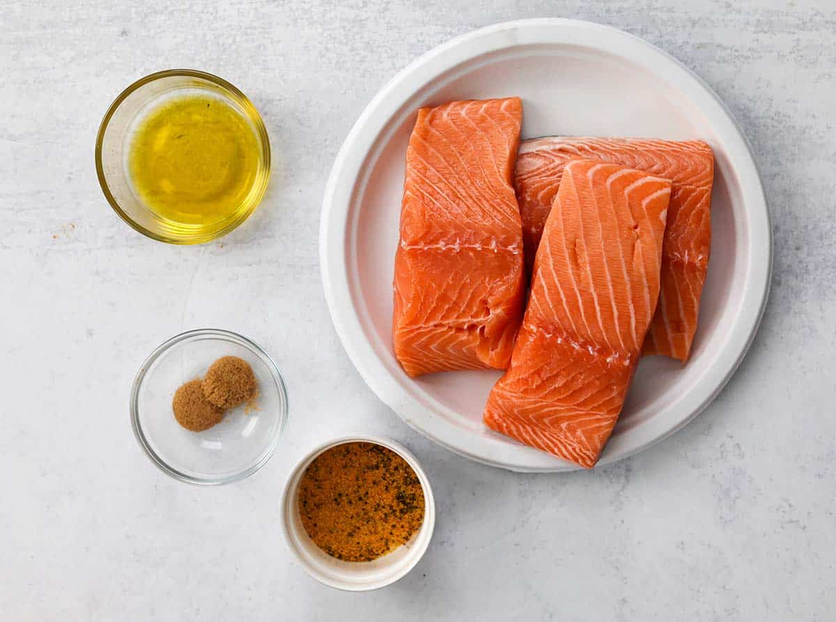 ingredients for lemon pepper salmon on a white surface. 