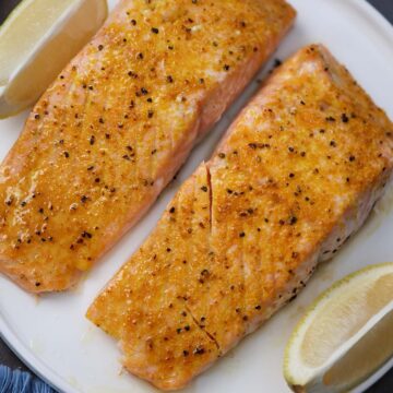 two baked lemon pepper salmon fillets.