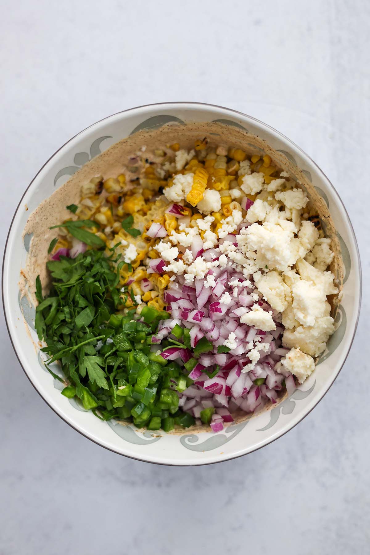 corn, cheese, onions, cilantro, and jalapenos in a large bowl. 