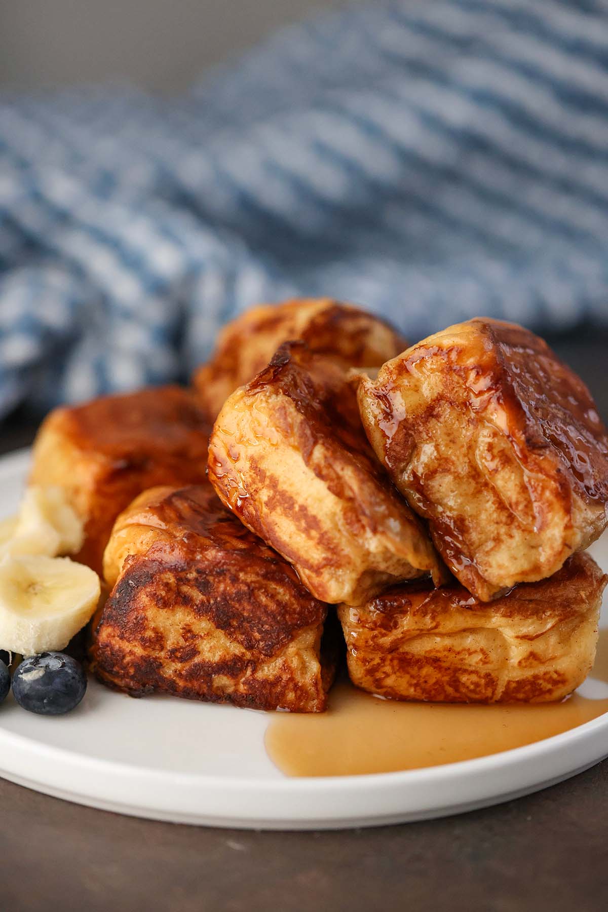 Hawaiian roll French toast with syrup and fruit on the side. 