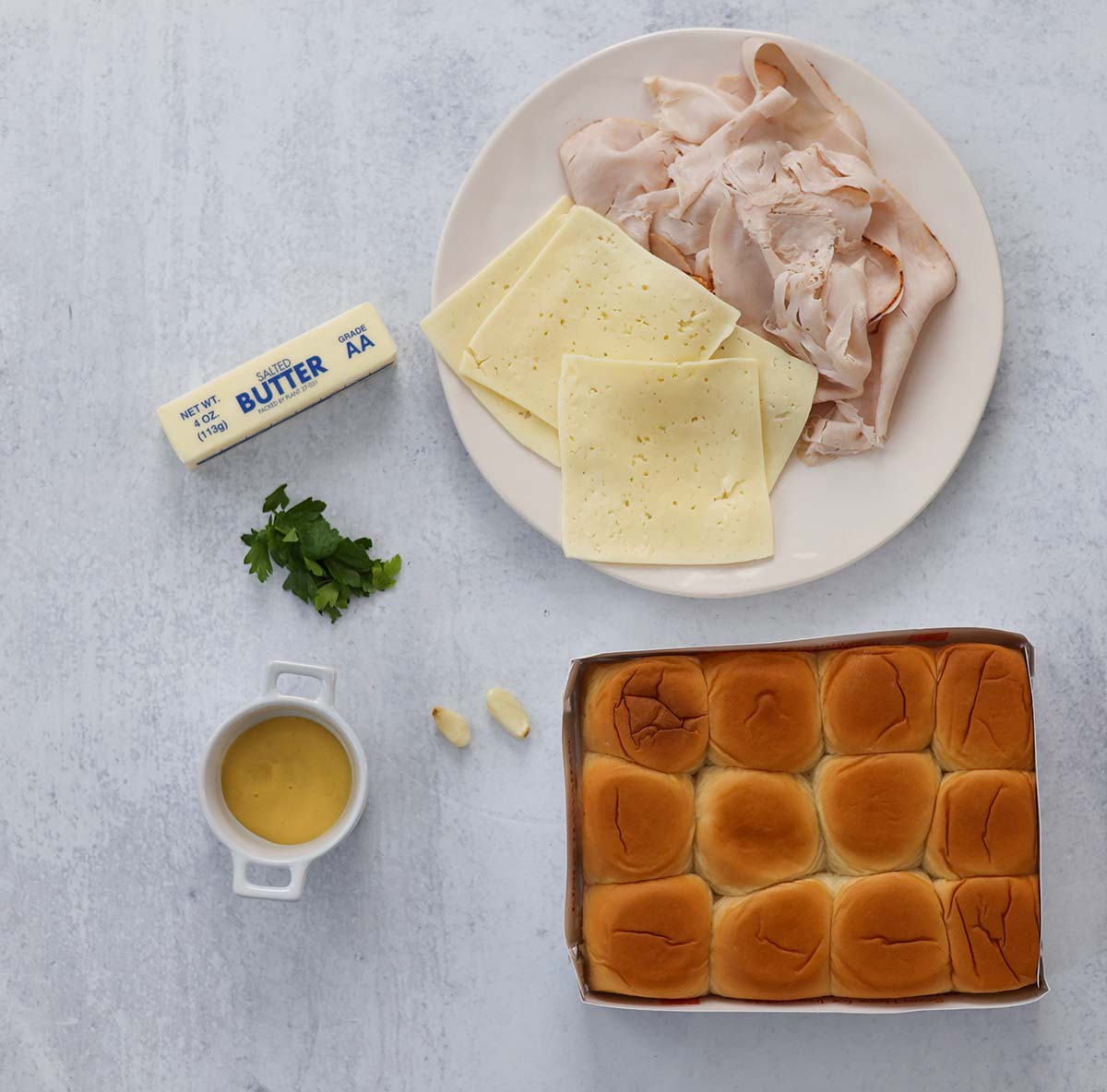 ingredients for turkey and cheese sliders on a white surface. 