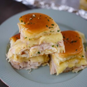 turkey and havarti cheese sliders on a plate.