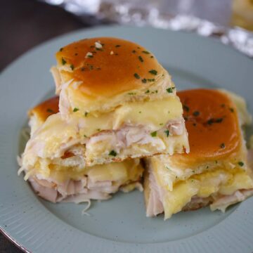 turkey and havarti cheese sliders on a plate.