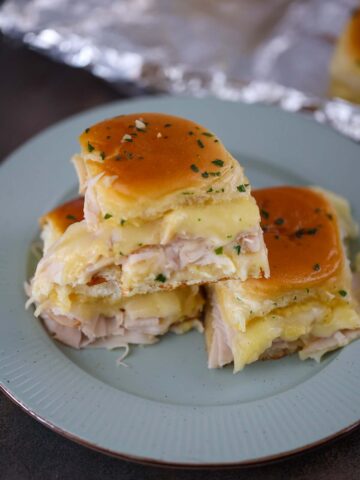 turkey and havarti cheese sliders on a plate.