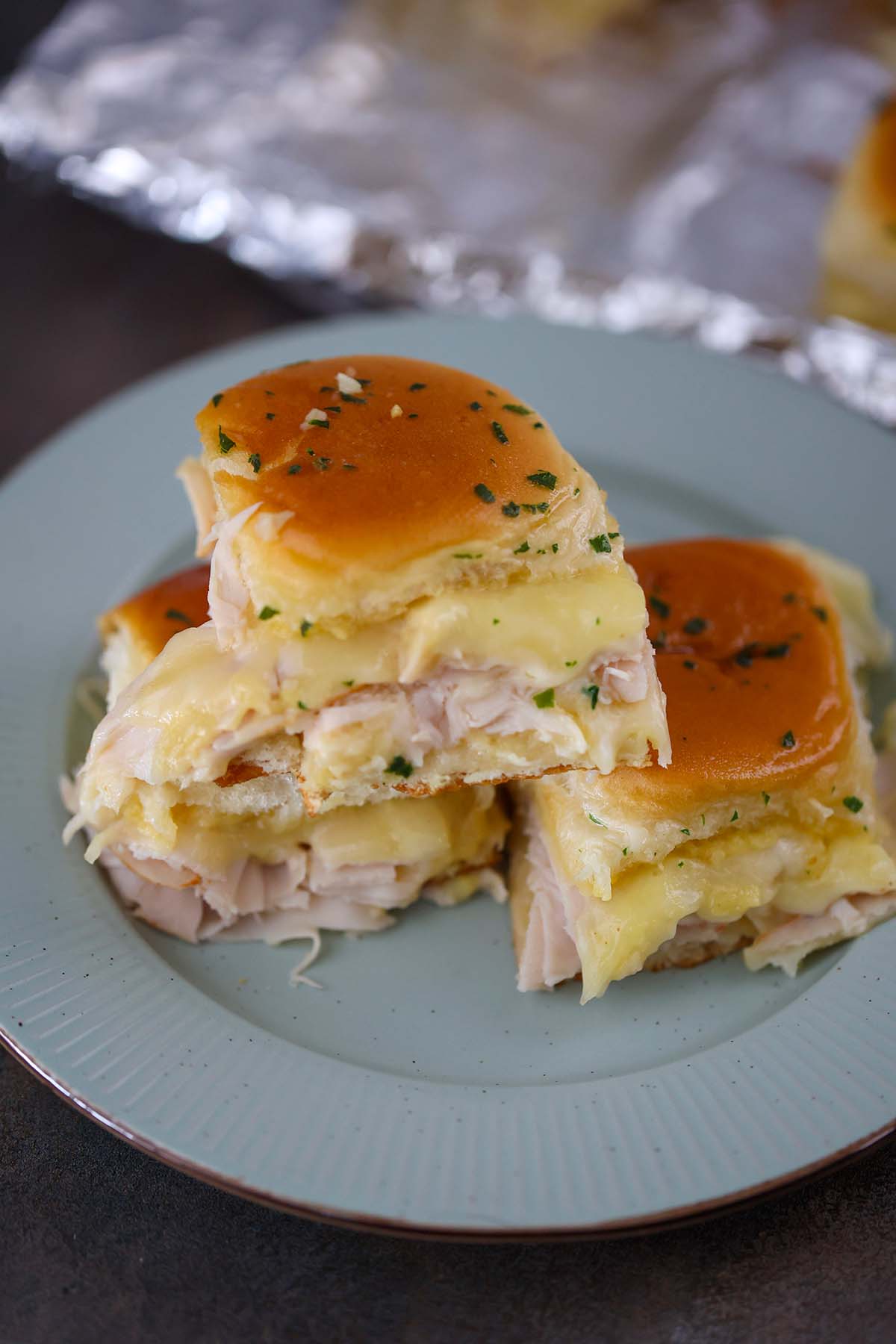 turkey and havarti cheese sliders on a plate. 