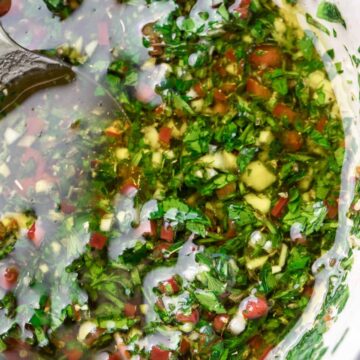 chimichurri in a white bowl up close.