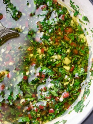 chimichurri in a white bowl up close.