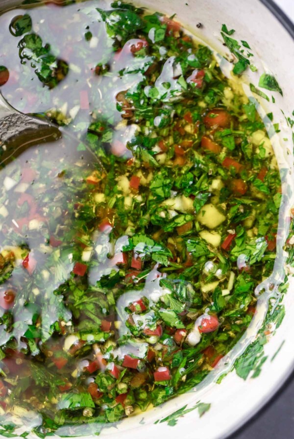 chimichurri in a white bowl up close.