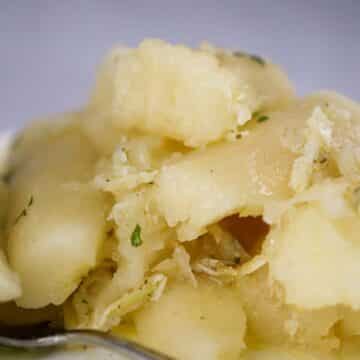 yuca con mojo on a plate with a spoon on the side.