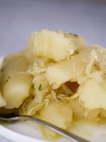 yuca con mojo on a plate with a spoon on the side.