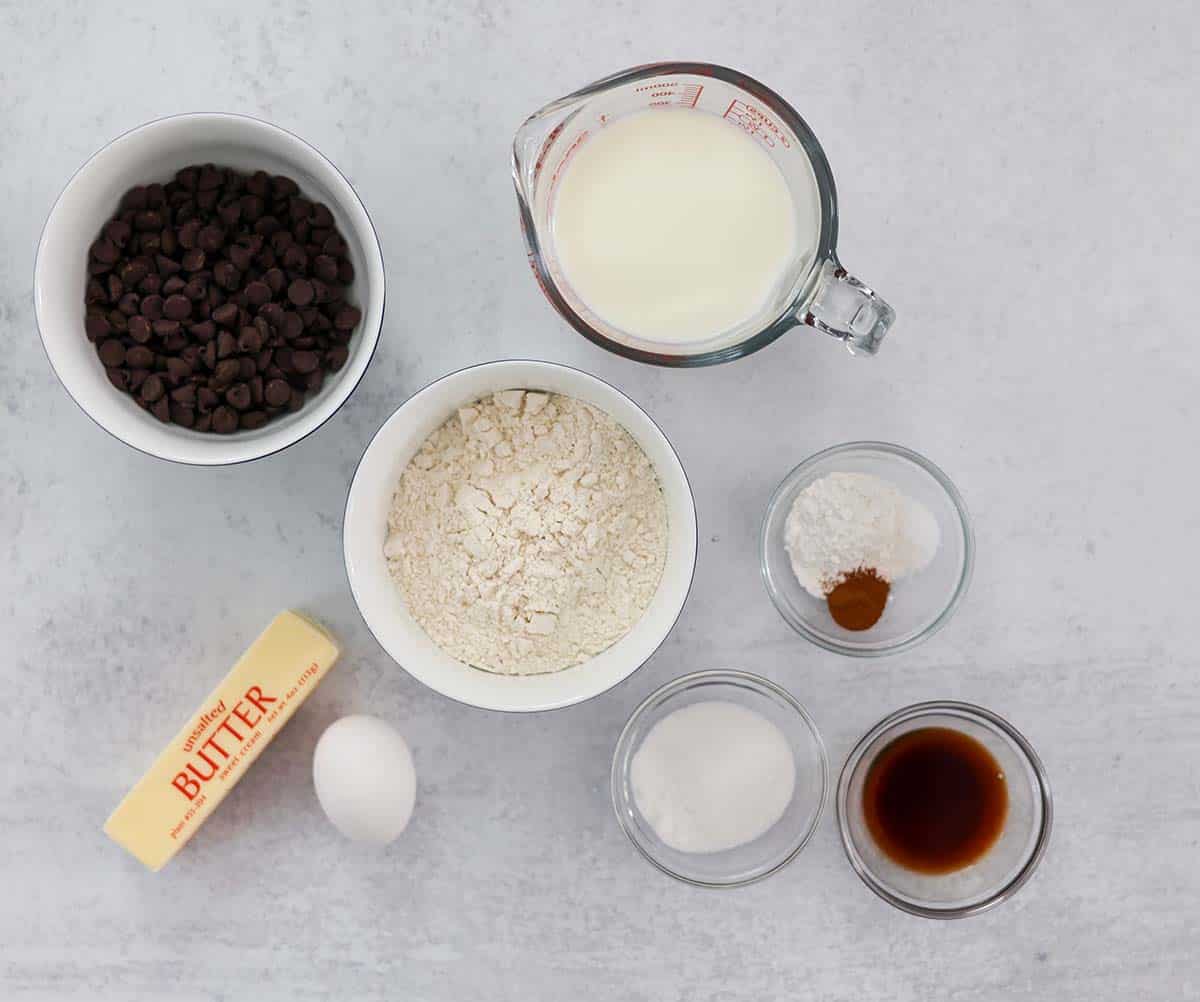 Ingredients for chocolate chip pancakes on a white surface. 