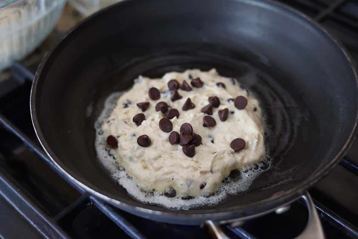Pancake cooking in a skillet on the stovetop. 