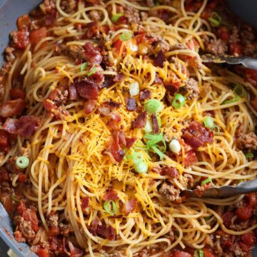 cowboy spaghetti in a pot with tongs.