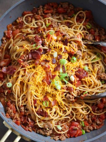 cowboy spaghetti in a pot with tongs.