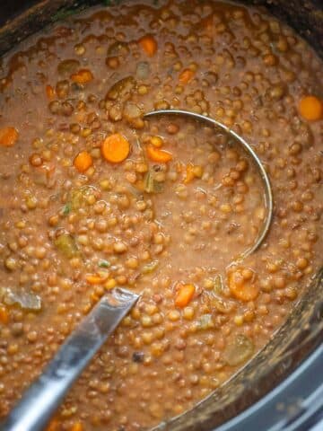 lentil soup in the crockpot with a ladle.