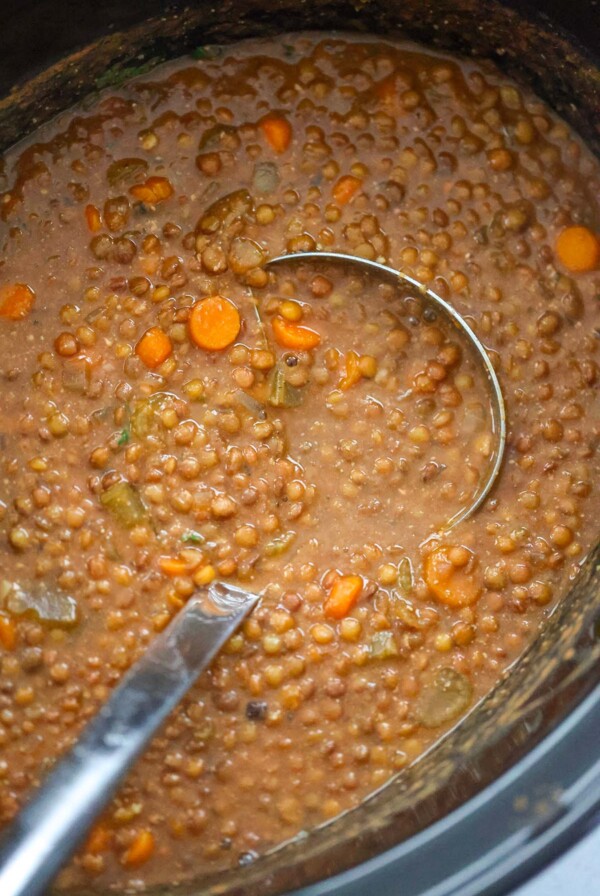 lentil soup in the crockpot with a ladle.