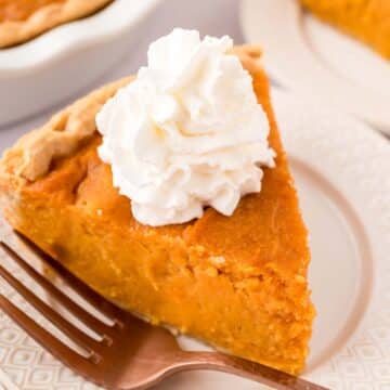 a slice of Southern sweet potato pie with whipped cream on top.
