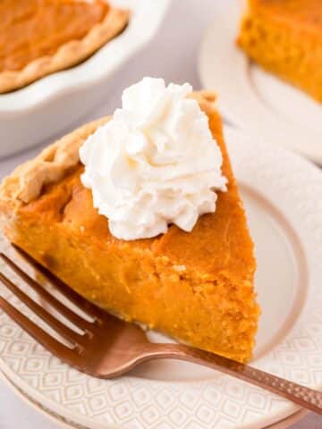 a slice of Southern sweet potato pie with whipped cream on top.