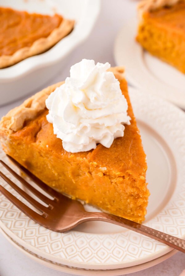 a slice of Southern sweet potato pie with whipped cream on top.