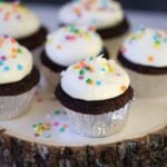 Six chocolate cupcakes with cream cheese frosting and sprinkles.