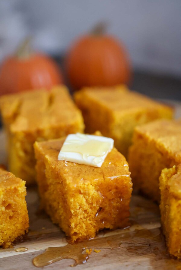 slices of pumpkin cornbread with butter and honey on top.