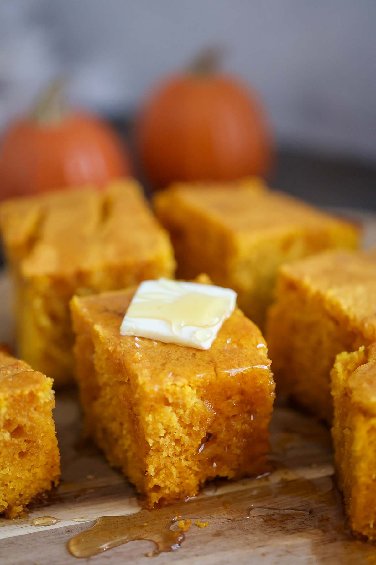 slices of pumpkin cornbread with butter and honey on top. 
